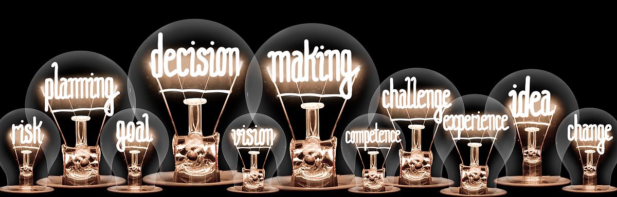 Leuchtende Glühbirnen, deren Glühdrähte Wörter wie "advertising", "marketing", "digital" oder "business" bilden