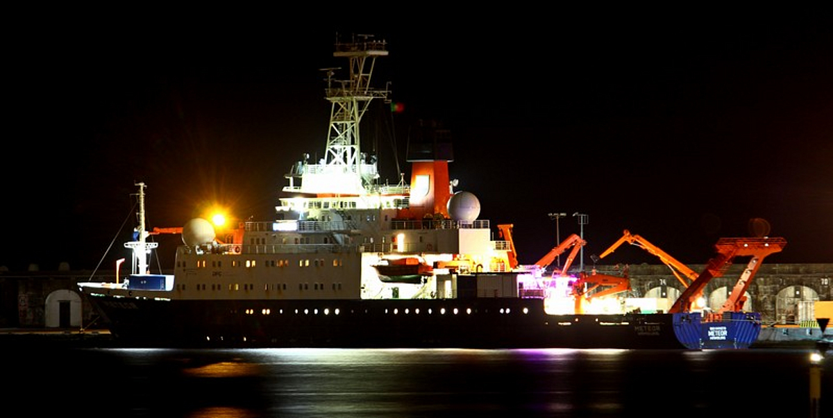 Das Forschungsschiff Meteor liegt in der Nacht im Hafen von Ponta Delgada, die Decks sind hell erleuchtet.