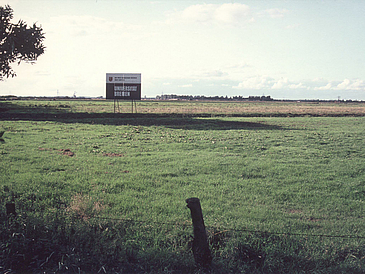 On a meadow that stretches to the horizon, you can see a construction sign with the inscription "University of Bremen".