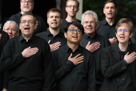 Chor der Universität Bremen: Männerstimmen mit Hand auf dem Herzen