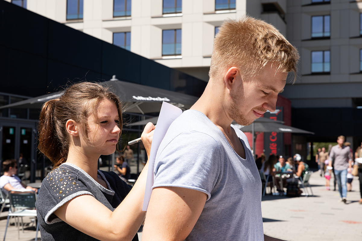 Eine Studentin schreibt auf einem Zettel