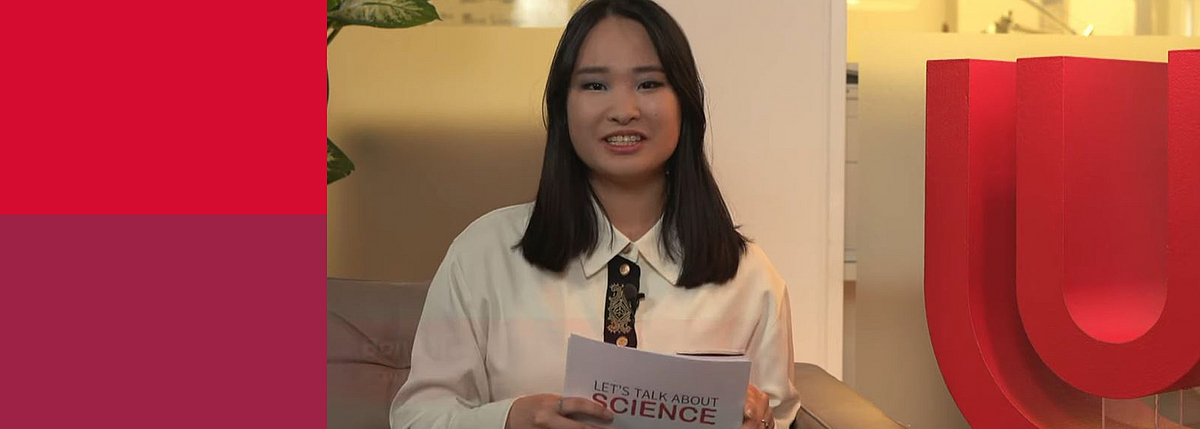 Eine junge Frau hat Moderationskärtchen in der Hand und blickt in die Kamera