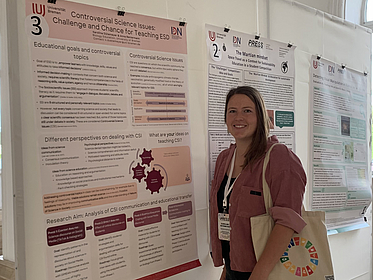 Karoline Dütemeyer steht neben ihrem Poster bei der Präsentation in Batumi