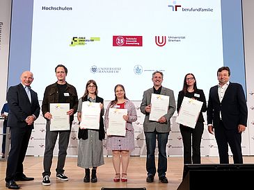 Gruppe von sieben Personen, davon fünf mit Zertifikaten in der Hand