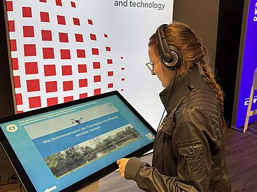 Women standing in front of an interactive touch screen.