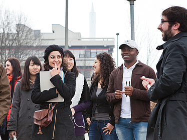 Eine Gruppe junger Menschen lacht zusammen.