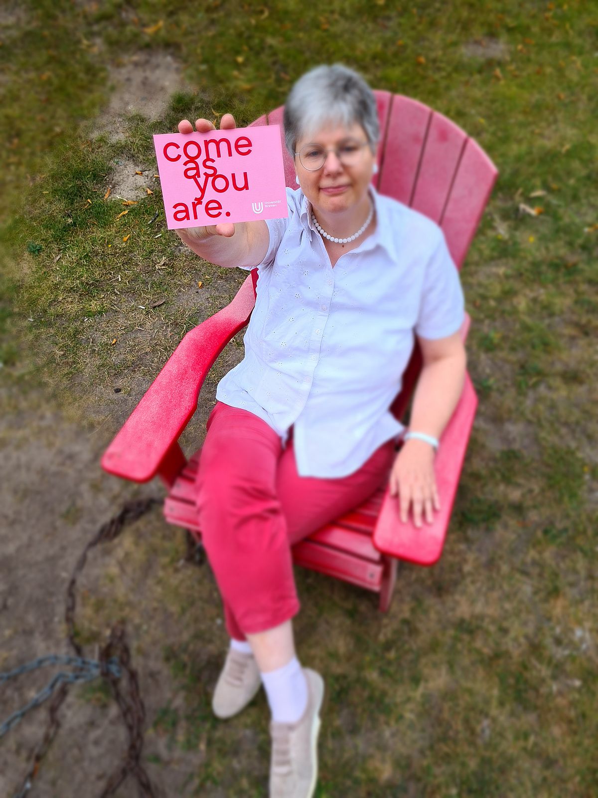 Studienberaterin hält Postkarte in die Kamera