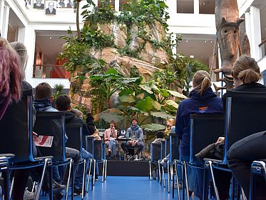 Froschperspektive auf das Podium mit Moderatorin und Autor