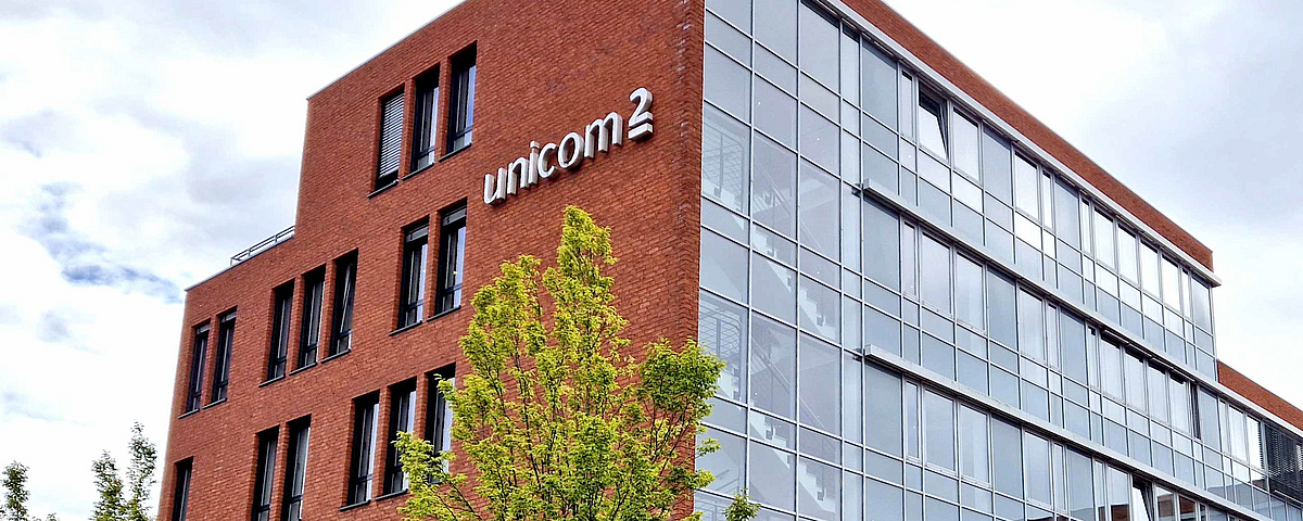 Backstein-Gebäude mit einem Baum im Vordergrund