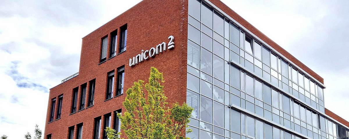 Backstein-Gebäude mit einem Baum im Vordergrund