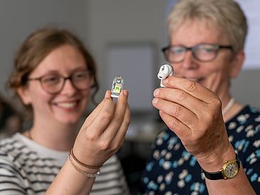 Zwei Frauen, die Hearables in der Hand halten