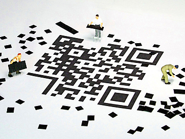 Digitale Helfer QR-Code mit kleinen Figuren, die kleine Schnipsel herumtragen