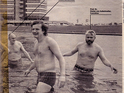 Three men go swimming in a lake on campus.