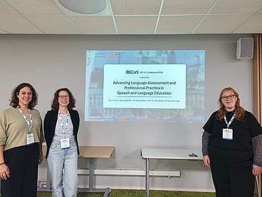 Vortragende Personen vor Vortragspräsentation