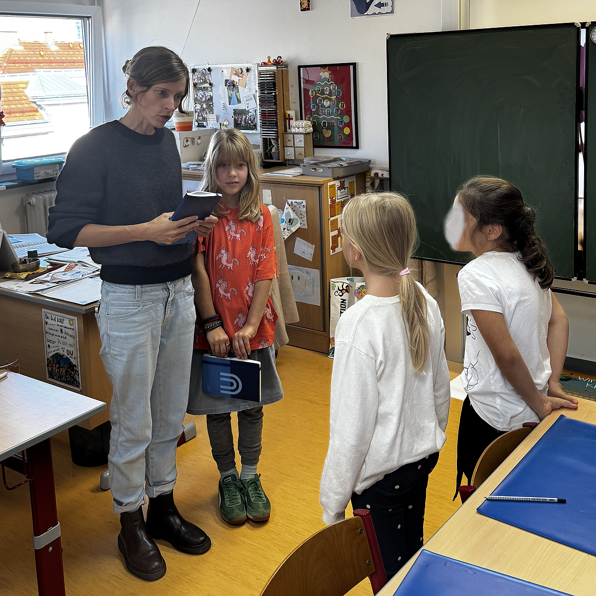 [Translate to English:] Projektkoordinatrin spricht mit Schülerinnen der Praxisschule