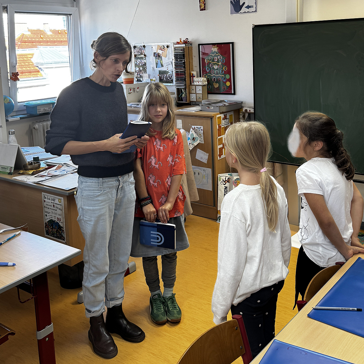 Projektkoordinatrin spricht mit Schülerinnen der Praxisschule