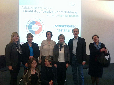 Gruppe von Menschen vor Schaubild