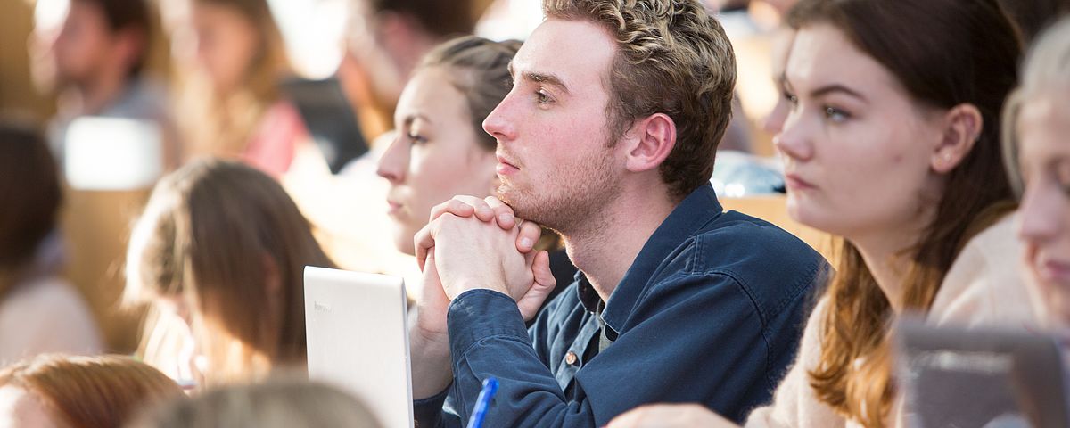 Attentive audience in the packed lecture hall.
