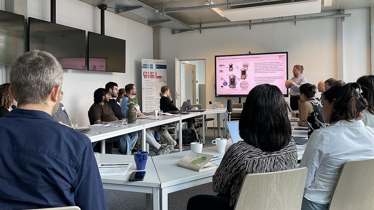 People sitting at a workshop, view from the back.