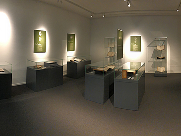 Lighted room with images, information boards and Glass showcases with exhibits