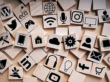 Scrabble-Steine mit Symbolen zu digitalen Medien/Internet