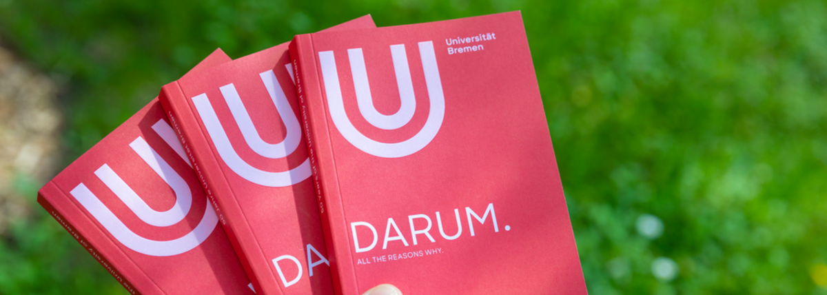 One hand holds three magazines, on the cover you can read the word DARUM