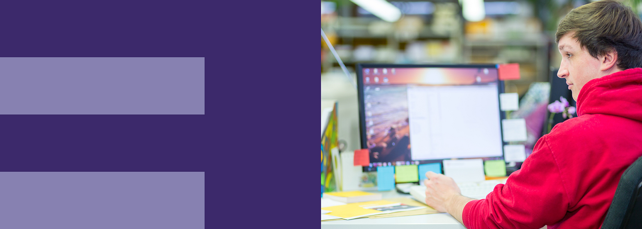 Zwei Personen stehen an einem Tisch mit Computern.