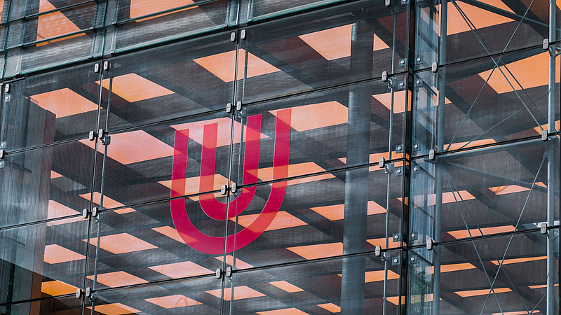 Logo der Universität auf der Glashalle.