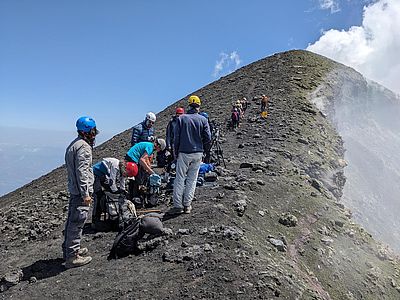 Forschungsgruppe auf steinigem Untergrund am Vulkan
