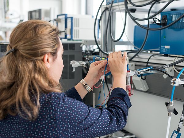 Eine Person verbindet in einem Labor Kabel miteinander.
