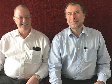 Zwei Männer lächeln in die Kamera