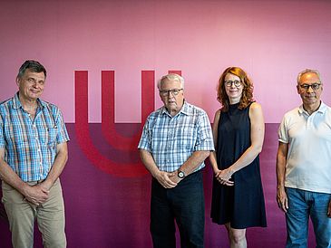Foto von Dr. Mandy Boehnke, Ruediger Mueller, Donald Bruce und Peter Haddawy vor Hintergrund mit Uni Bremen-Logo