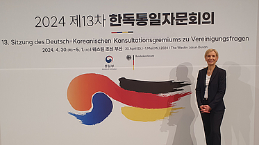 Jutta Günther vor dem Banner der Veranstaltung