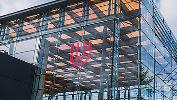 Das Logo der Universität Bremen an der Fassade der Glashalle.