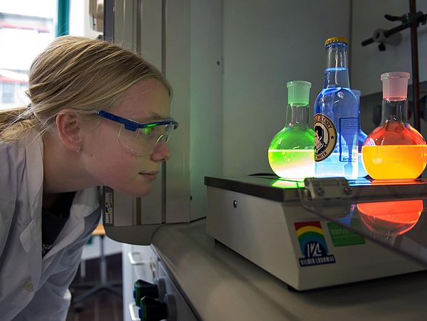 Kleine Forscherin beobachtet Reagenzgläser