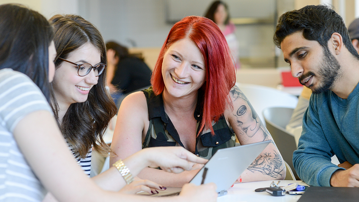 Junge Menschen arbeiten am Laptop.