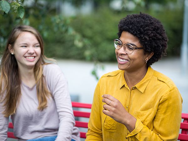 Zwei Studierende draußen im Gespräch.