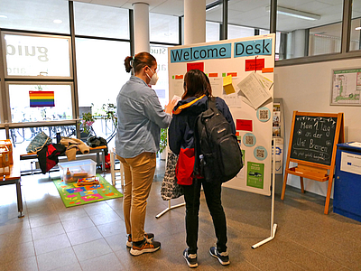 Studierende vor der Infotafel Welcome Desk
