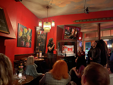 Camilla Tossi steht vor ihrem Publikum in einer Bar.