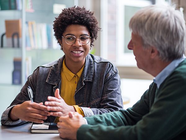 A student and a senior student in conversation.