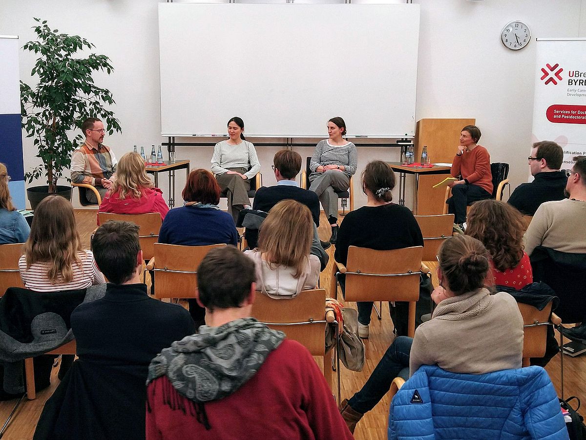 Das Bild zeigt Gäste und Podium bei der Veranstaltung "Leaving Academia" im Jahr 2022.