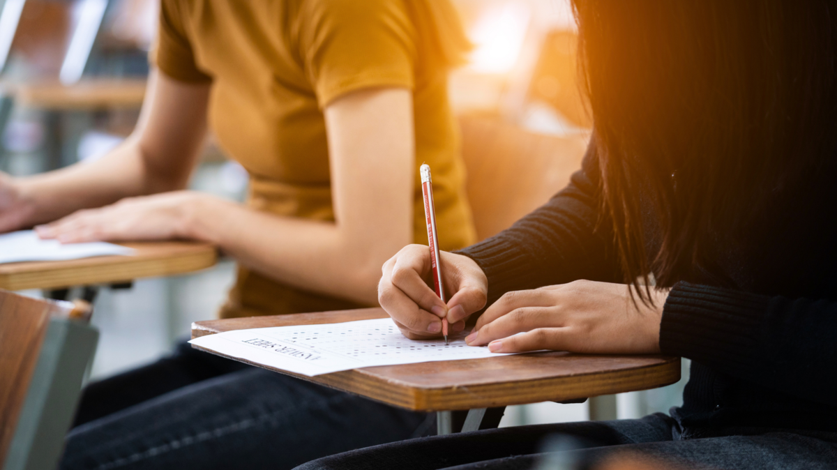 Two people writing something down.