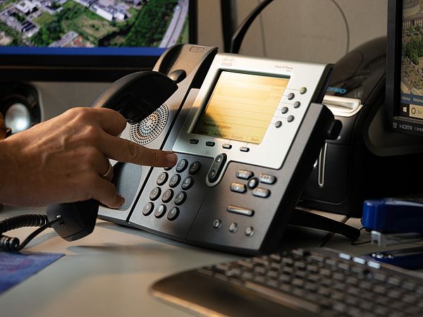 Person dials the telephone.