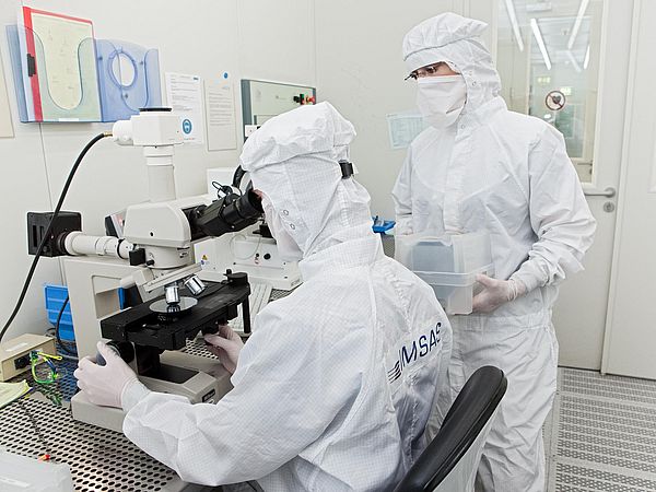 Personen in Schutzkleidung bei der Arbeit im Labor.