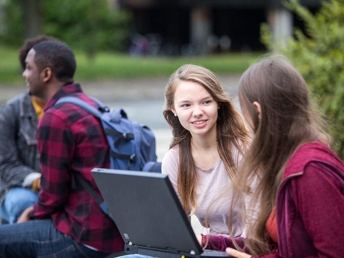 Studierende arbeiten draußen.
