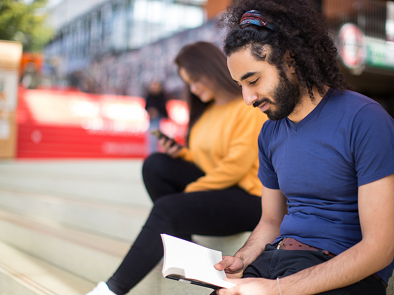Students on the stairs of the glass hall.