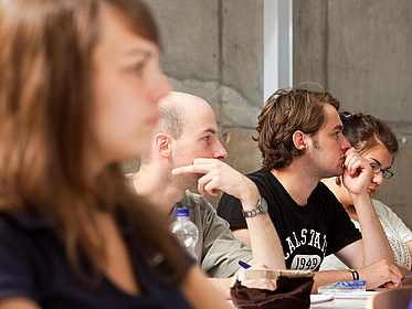 A number of listeners sitting in a row in a seminar room.