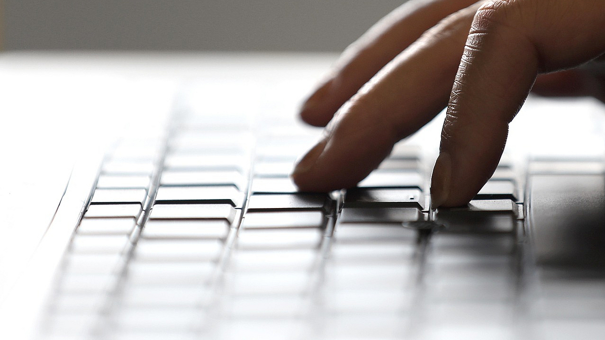 hand typing on a laptop keyboard