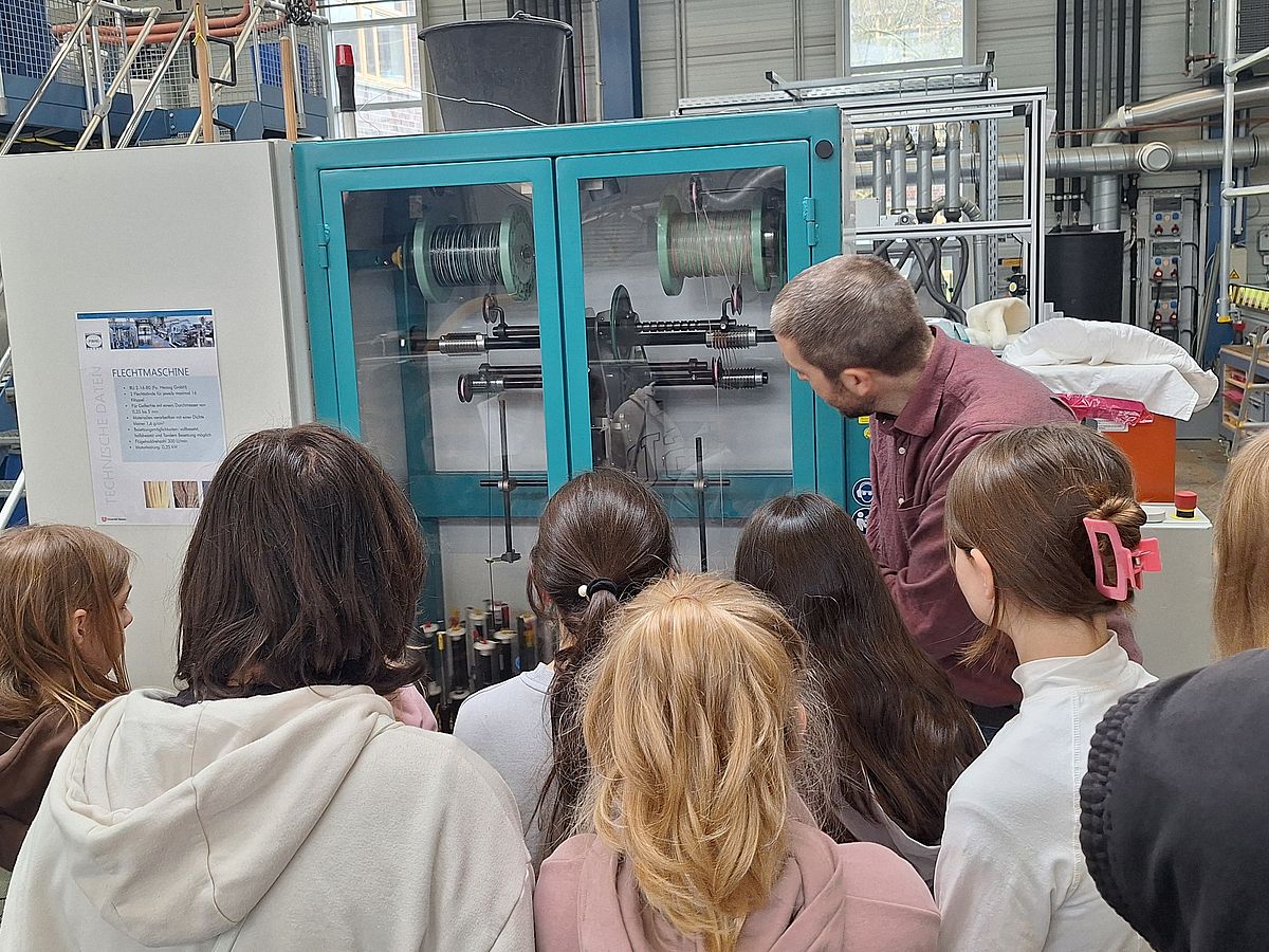 Kinder vor einer Faden-Wickelmaschine