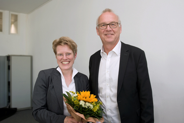 Photo of a woman with flowers in her hand and a man